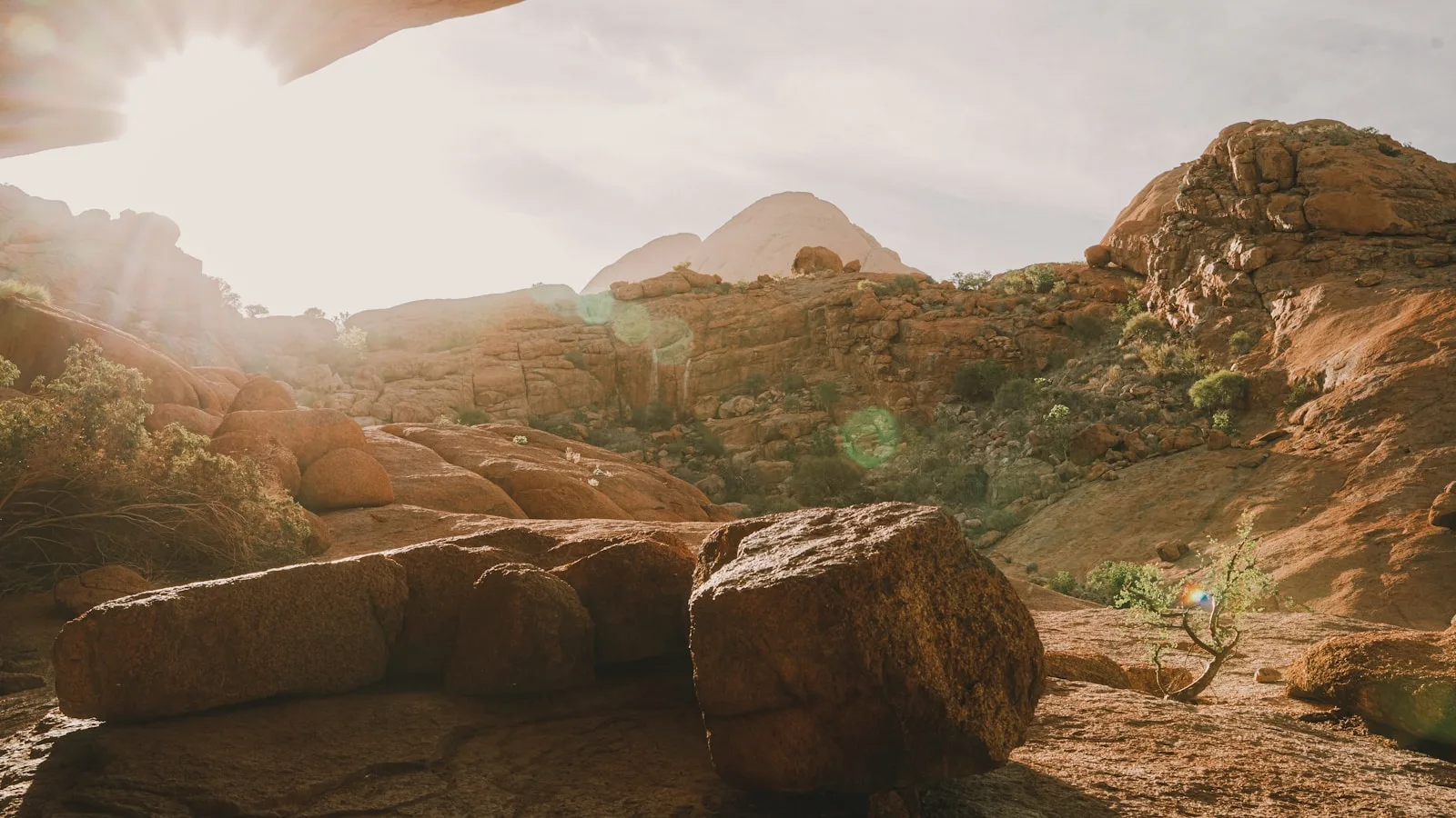 Sunlight flaring over golden desert boulders
